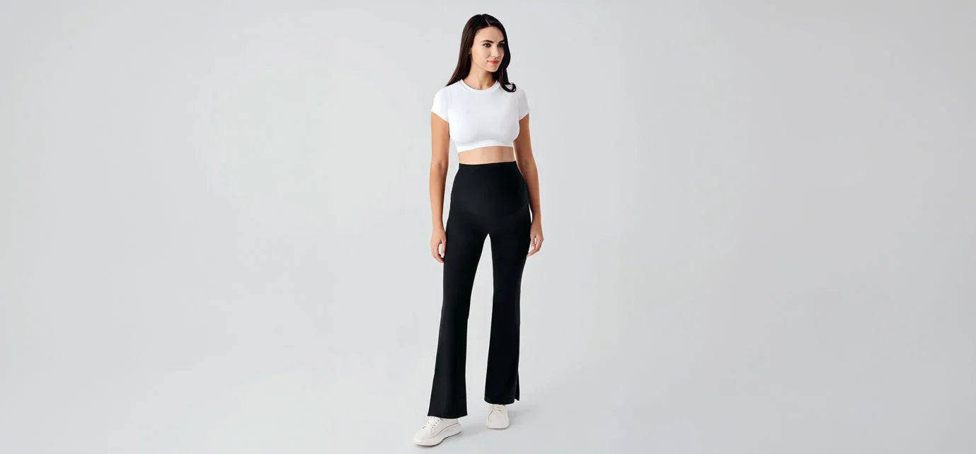 Woman modeling black high-waisted maternity pants and white crop top, Artış Collection