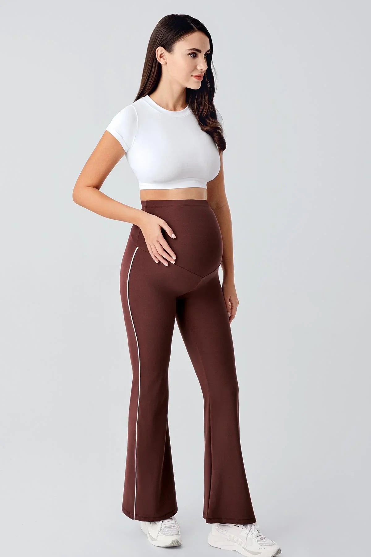 Artış Collection brown high-waisted flared maternity leggings with side piping, worn by a model
